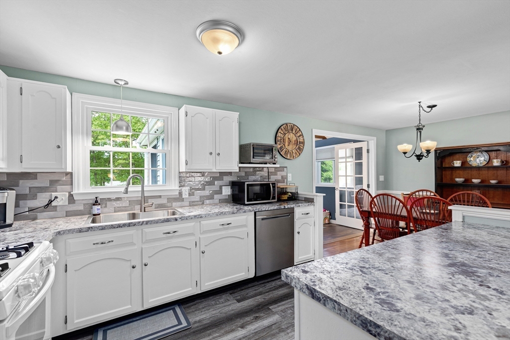 29 Worrall Road Plymouth, MA 02360 - Photo 13 of 38 a kitchen with stainless steel appliances granite countertop a sink dishwasher stove and wooden cabinets