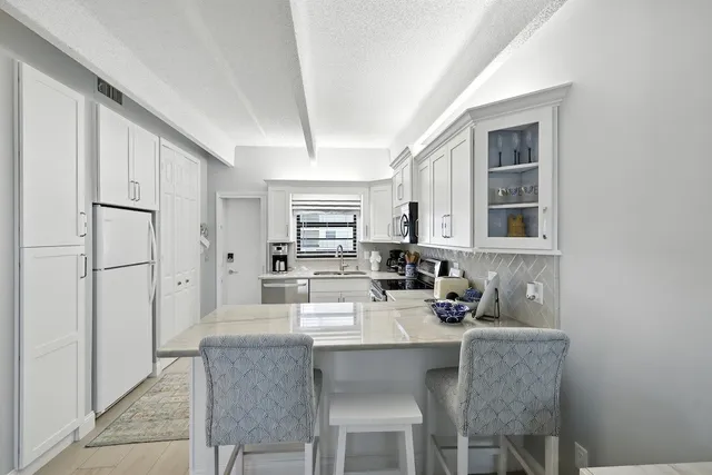 a kitchen with stainless steel appliances a sink stove and refrigerator