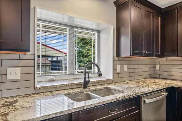 a kitchen with granite countertop a sink and a window