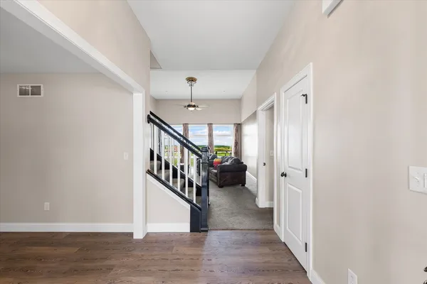 a view of an entryway with wooden floor and stairs