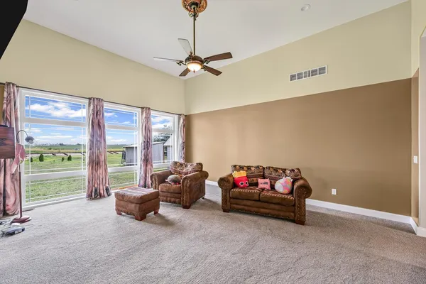 a living room with furniture a flat screen tv and a large window