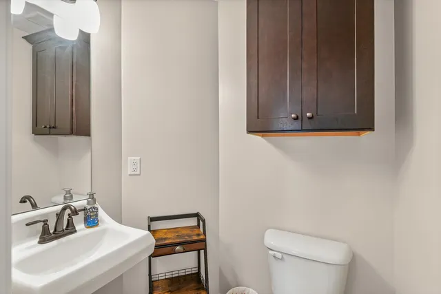 a bathroom with a sink a toilet and mirror