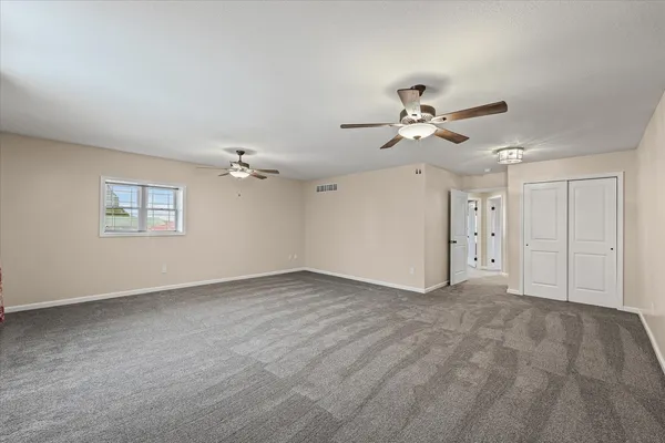 a view of an empty room with a ceiling fan