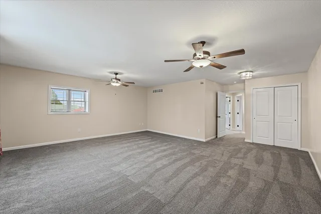 a view of an empty room with a ceiling fan