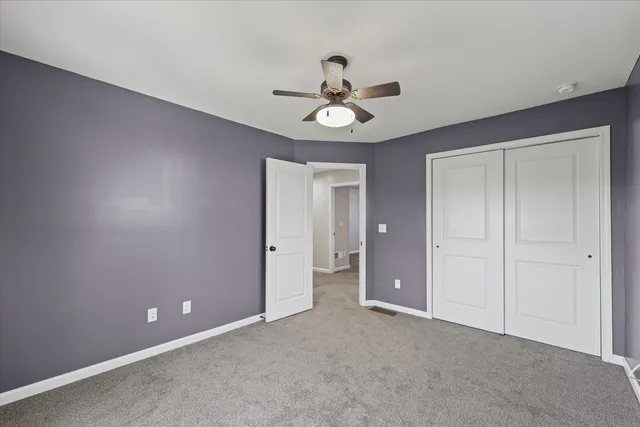 a view of an empty room and a ceiling fan window