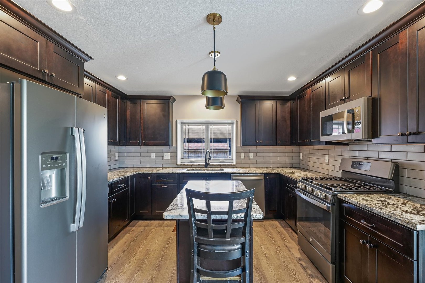 103 1st Street Strawn, IL 61775 - Photo 8 of 50 a kitchen with stainless steel appliances granite countertop a stove refrigerator and cabinets