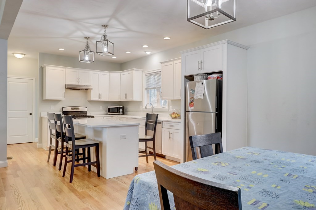 7 Marshall Street, Unit 7 Ayer, MA 01432 - Photo 24 of 31 a kitchen with stainless steel appliances granite countertop a dining table chairs refrigerator and cabinets