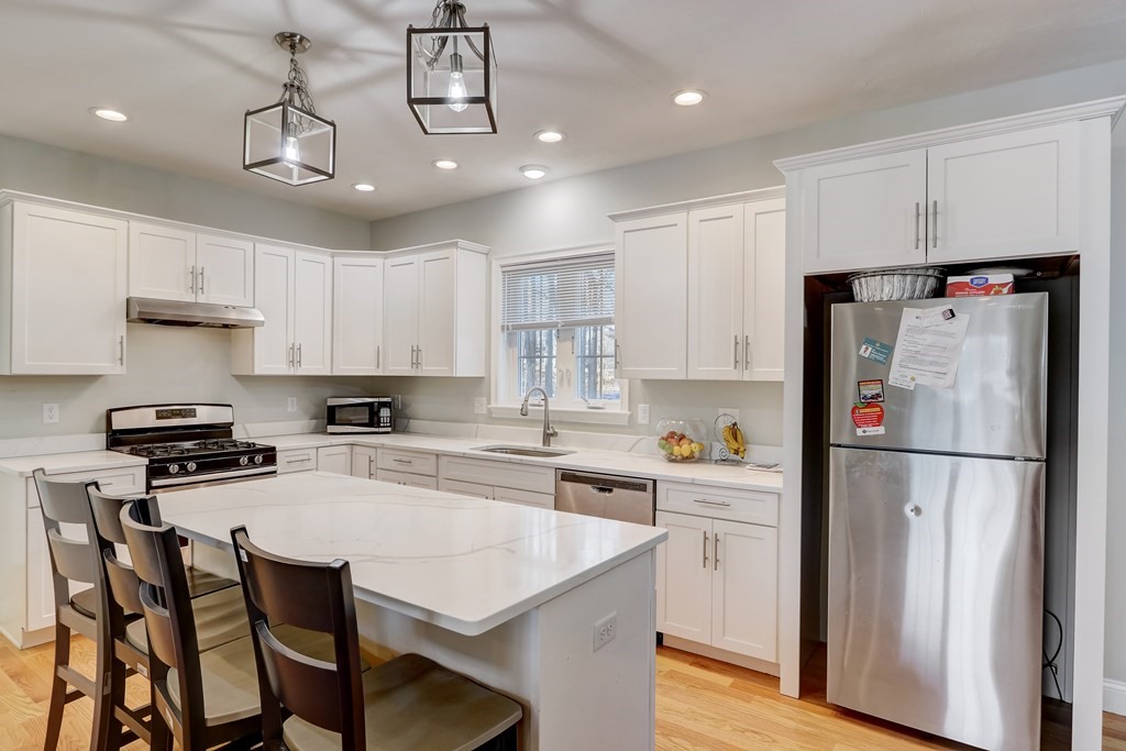 7 Marshall Street, Unit 7 Ayer, MA 01432 - Photo 25 of 31 a kitchen with stainless steel appliances a refrigerator a stove a sink a center island and chairs