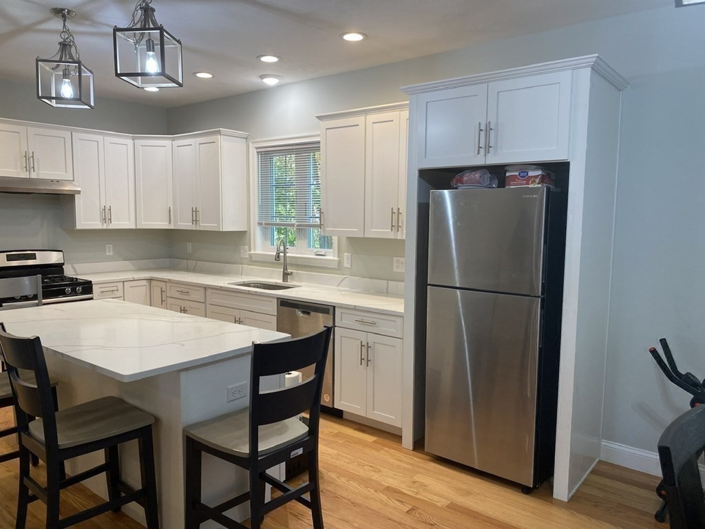 7 Marshall Street, Unit 7 Ayer, MA 01432 - Photo 9 of 31 a kitchen with stainless steel appliances granite countertop a refrigerator a sink a stove a dining table and chairs