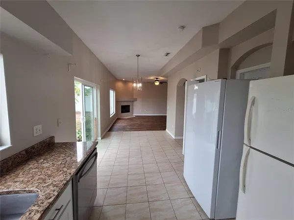 a view of a refrigerator in kitchen and a kitchen