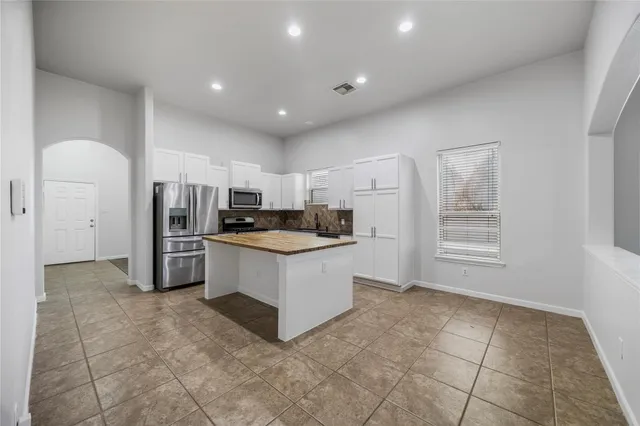 a kitchen with stainless steel appliances a refrigerator sink and cabinets