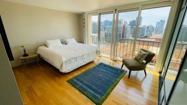 a bedroom with a bed and wooden floor