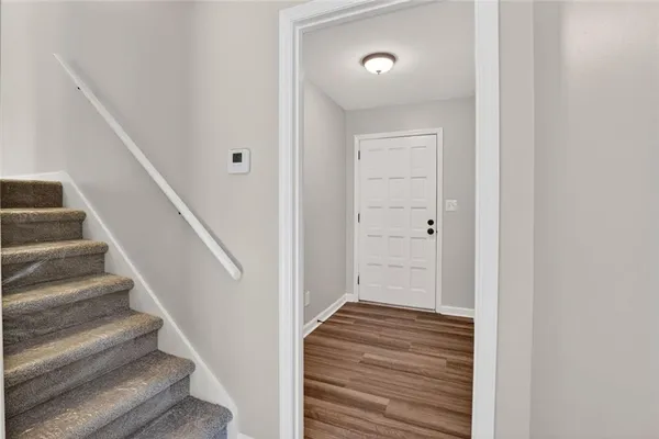 a view of a hallway with wooden floor and entryway