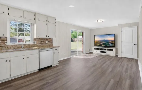 a open kitchen with cabinets and wooden floor