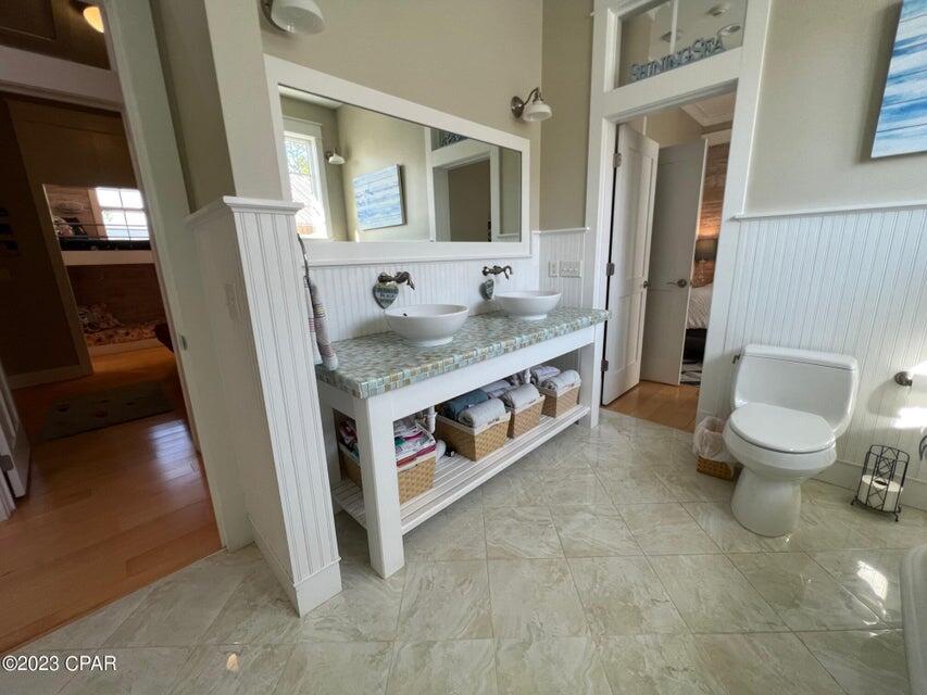 114 Parkshore Drive Panama City Beach, FL 32413 - Photo 17 of 86 a bathroom with a granite countertop double vanity sink a mirror and a toilet