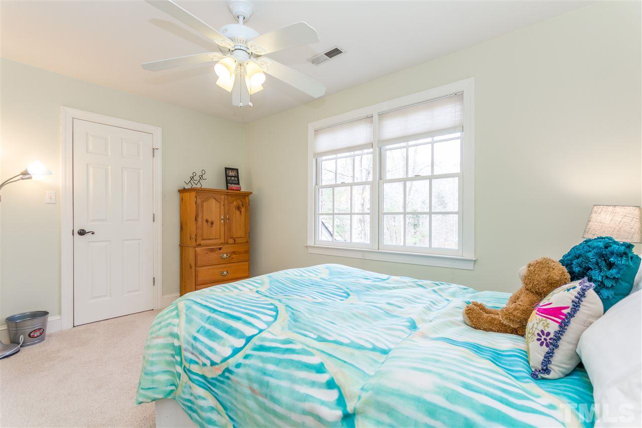 10616 Cahill Road Raleigh, NC 27614 - Photo 15 of 24 a bedroom with a bed and a chandelier