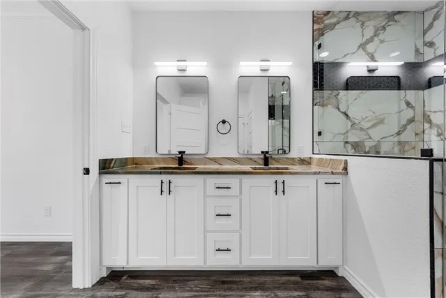 a bathroom with double vanity and a mirror