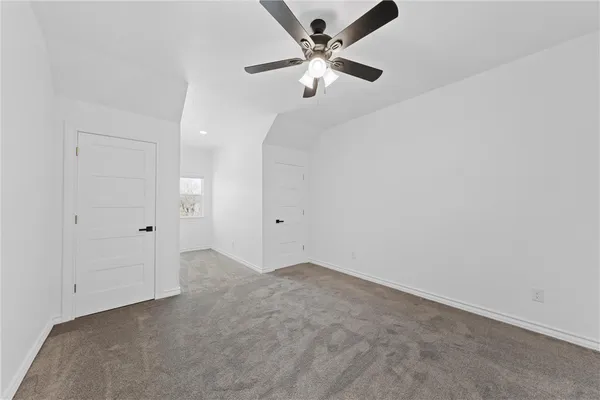 an empty room with a ceiling fan and a window