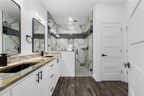 a spacious bathroom with a granite countertop sink mirror and shower