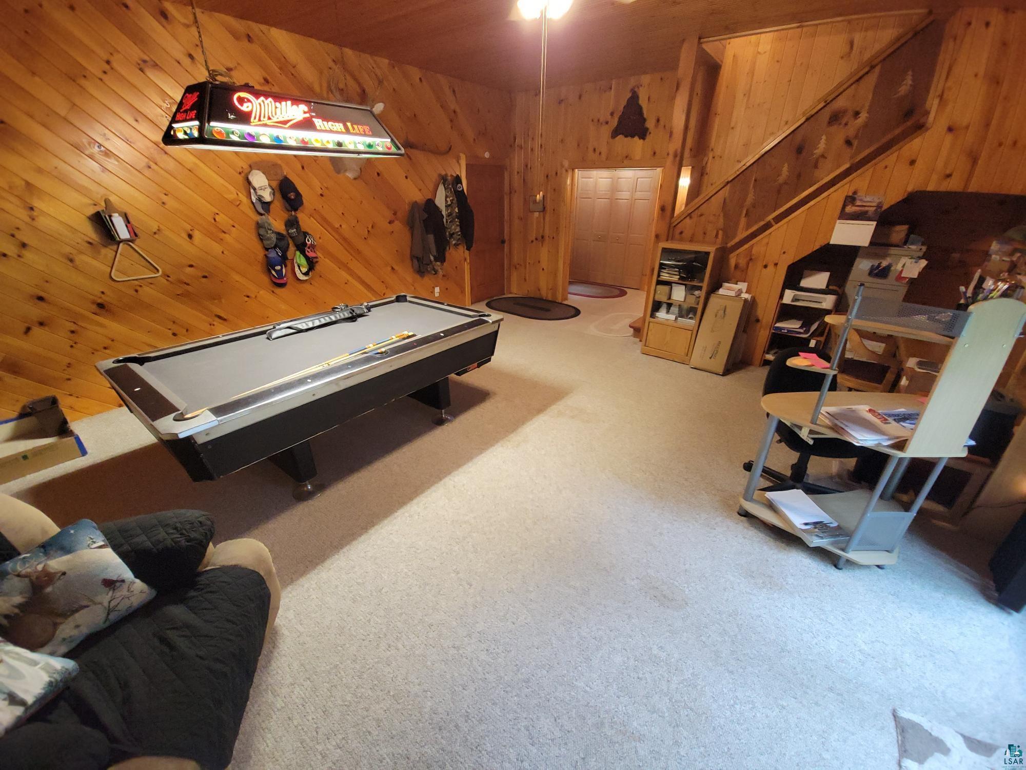 181 Linnell Road Grand Marais, MN 55604 - Photo 61 of 77 Carpeted recreation area featuring wood-paneled walls and a wooden staircase