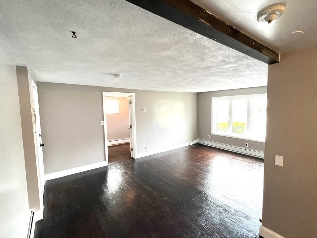 150 Locust Street, Unit 1 Winthrop, MA 02152 - Photo 6 of 11 a view of empty room with wooden floor and fan