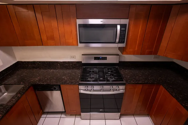 a kitchen with granite countertop a stove and a microwave
