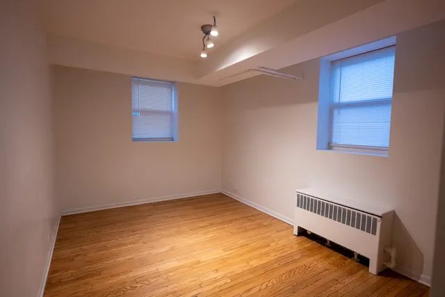a view of empty room with wooden floor
