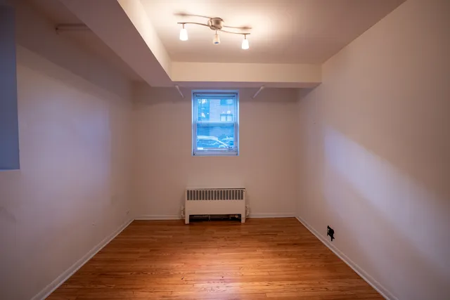 an empty room with a piano and wooden floor