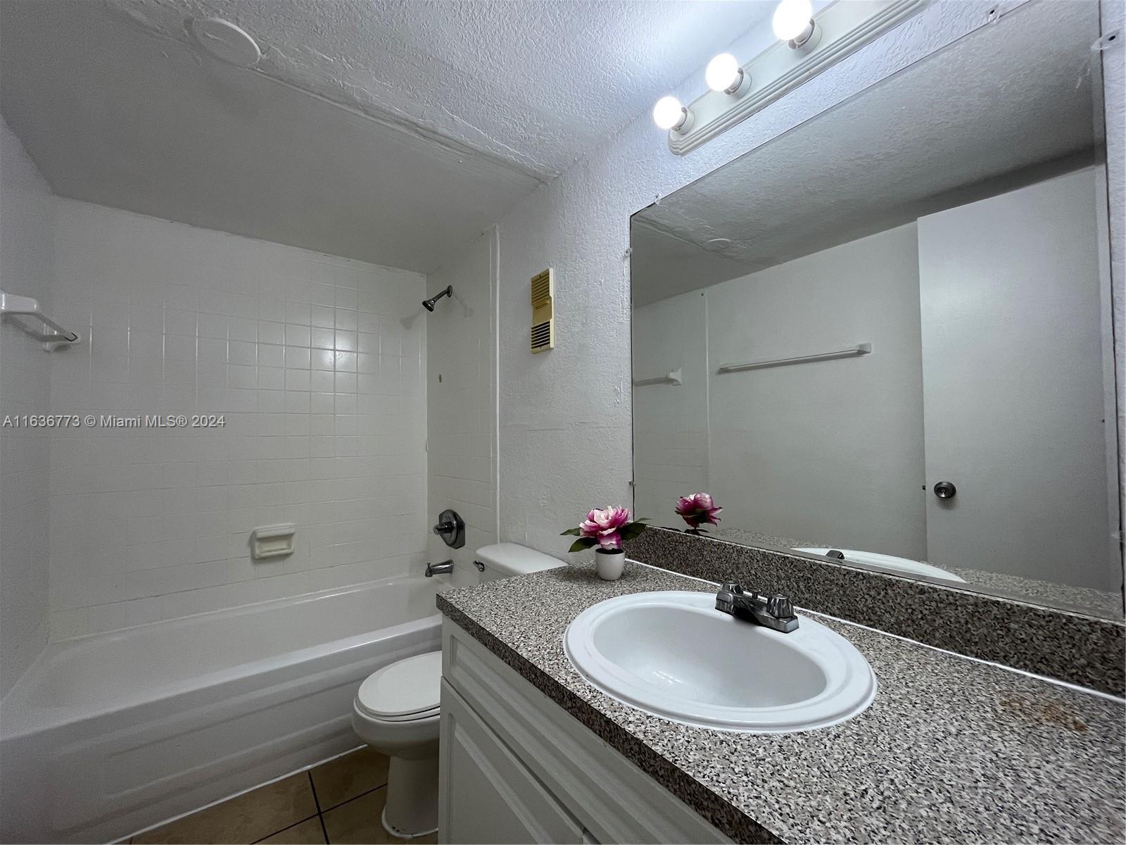 Hialeah Hialeah, FL 33012 - Photo 15 of 21 a bathroom with a granite countertop sink toilet a mirror and shower