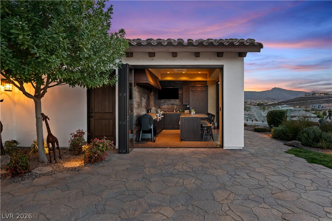 1123 Christian Road Henderson, NV 89002 - Photo 71 of 94 An inviting outdoor kitchen space features built-in appliances and ample seating, perfect for entertaining.