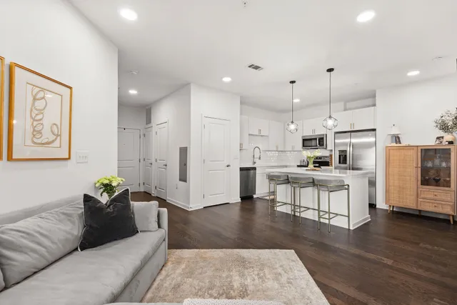 a living room with stainless steel appliances kitchen island granite countertop furniture and a view of kitchen