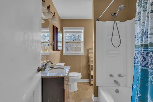 a bathroom with a granite countertop sink a toilet and shower