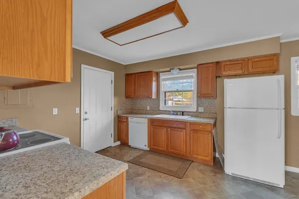 a kitchen with granite countertop a refrigerator and a sink