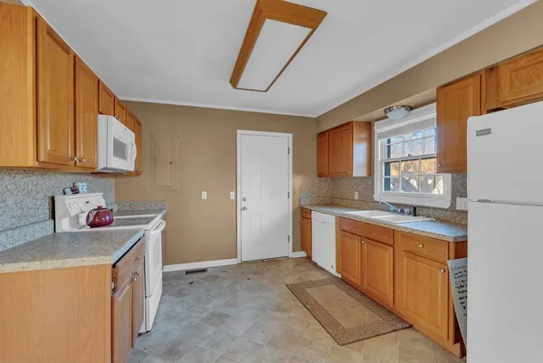 a kitchen with a sink a refrigerator and cabinets