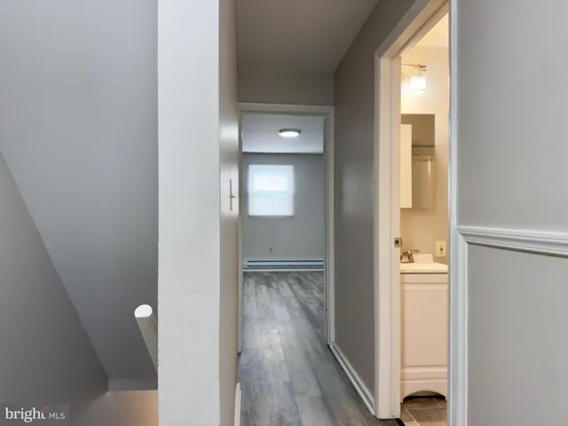 a view of a room with wooden floor mirror and windows
