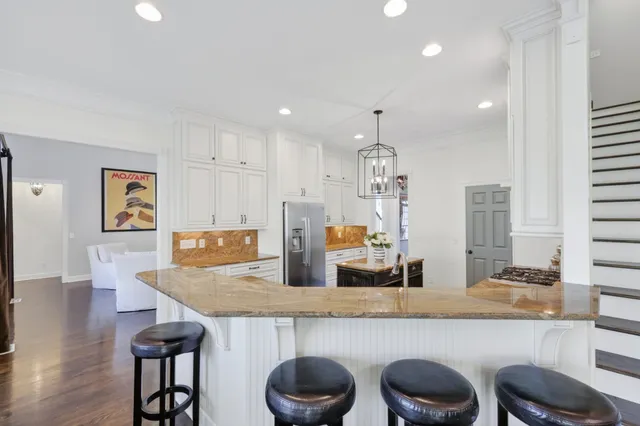 a living room with furniture a chandelier and a dining table