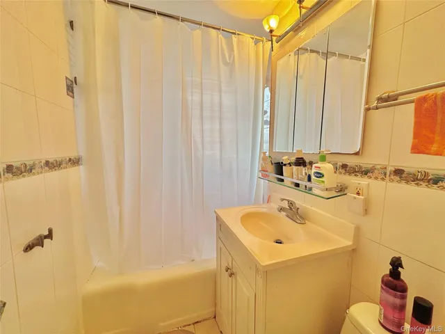 a bathroom with a sink a toilet and shower curtain