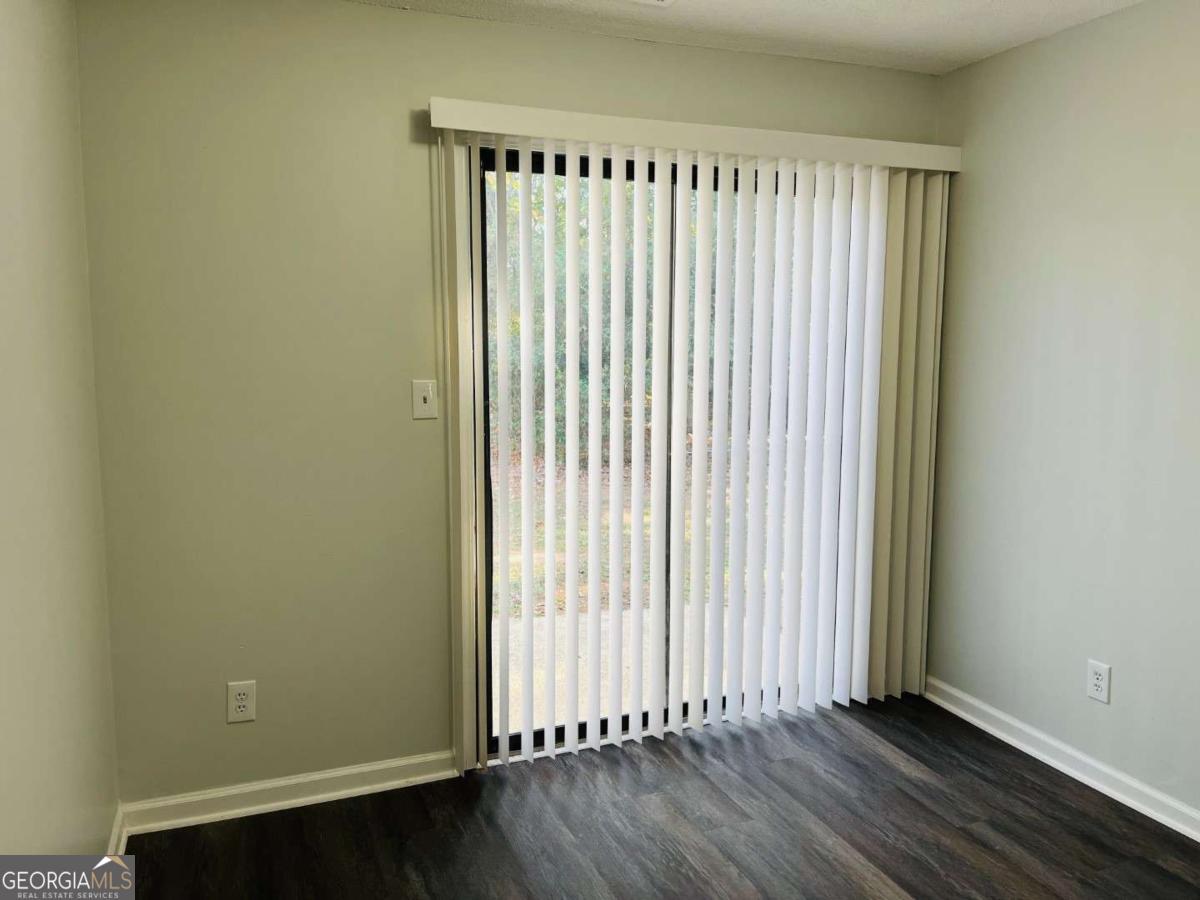 5614 Windwood Road, Unit 5614 Atlanta, GA 30349 - Photo 12 of 26 an empty room with wooden floor and a window