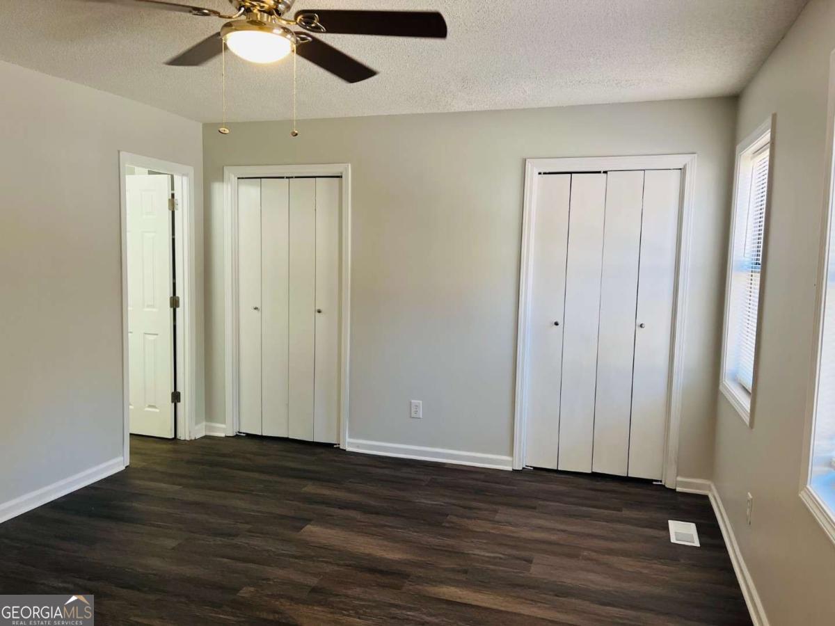5614 Windwood Road, Unit 5614 Atlanta, GA 30349 - Photo 22 of 26 an empty room with wooden floor fan and windows