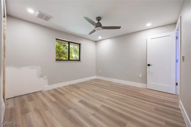 a spacious bedroom with a bed and a dresser