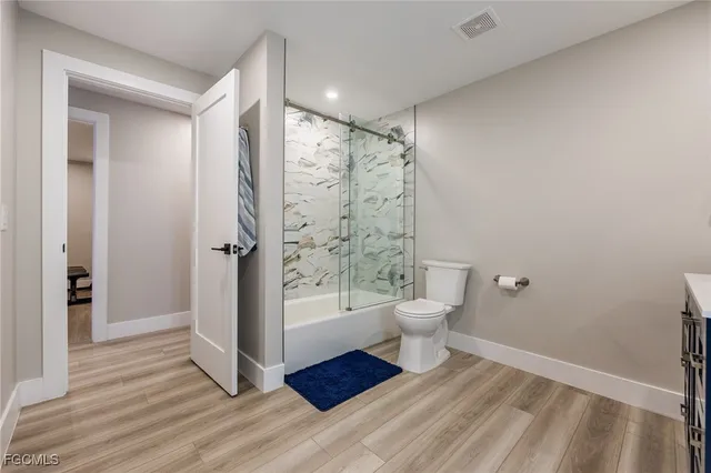 a spacious bathroom with a double vanity sink a mirror and a shower