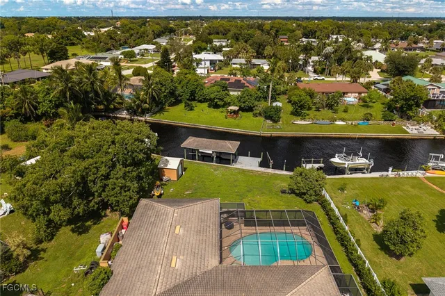 an aerial view of a residential houses with outdoor space and lake view