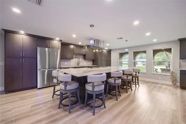 a kitchen with granite countertop a refrigerator and microwave