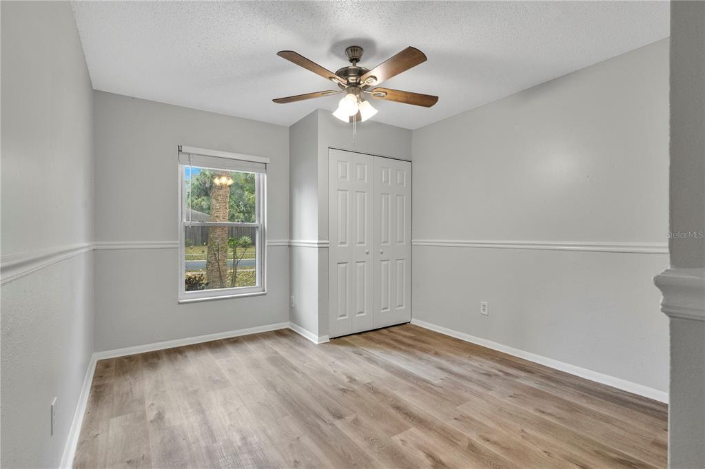 709 Sailfish Road Winter Springs, FL 32708 - Photo 13 of 28 an empty room with wooden floor and ceiling fan