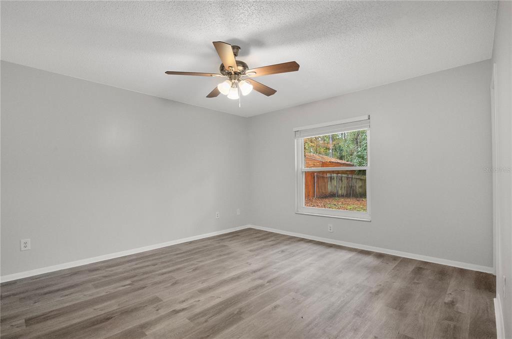 709 Sailfish Road Winter Springs, FL 32708 - Photo 16 of 28 an empty room with wooden floor fan and windows