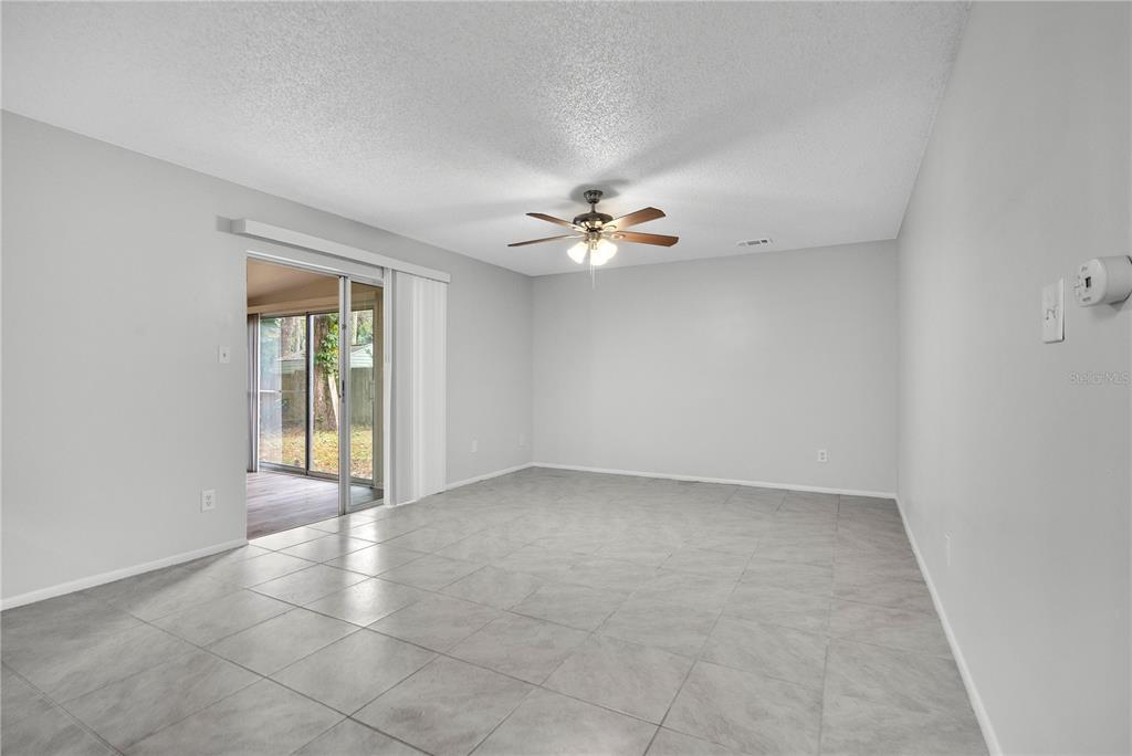 709 Sailfish Road Winter Springs, FL 32708 - Photo 6 of 28 an empty room with chandelier fan and windows