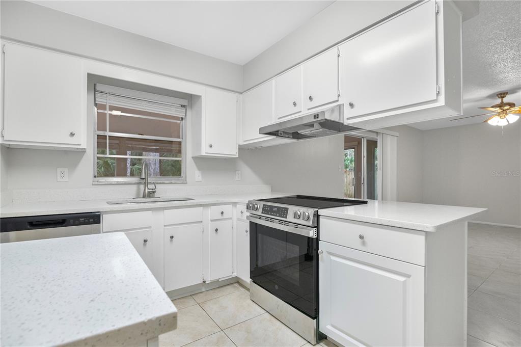 709 Sailfish Road Winter Springs, FL 32708 - Photo 8 of 28 a kitchen with granite countertop white cabinets and white appliances