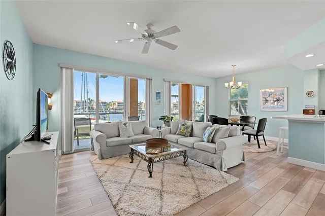 a living room with furniture large window and wooden floor