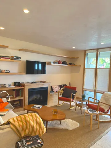 a living room with furniture a fireplace and flat screen tv