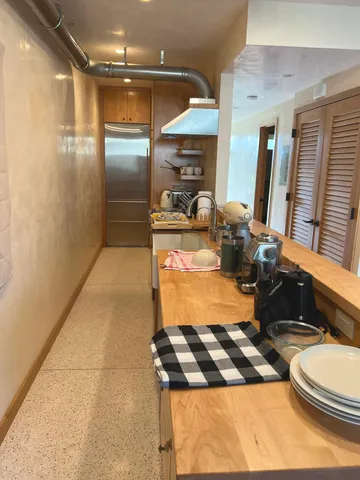 a room with stainless steel appliances kitchen island granite countertop a sink and cabinets